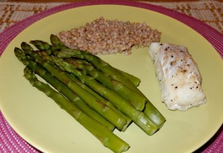 Fish on asparagus with basil butter and groats