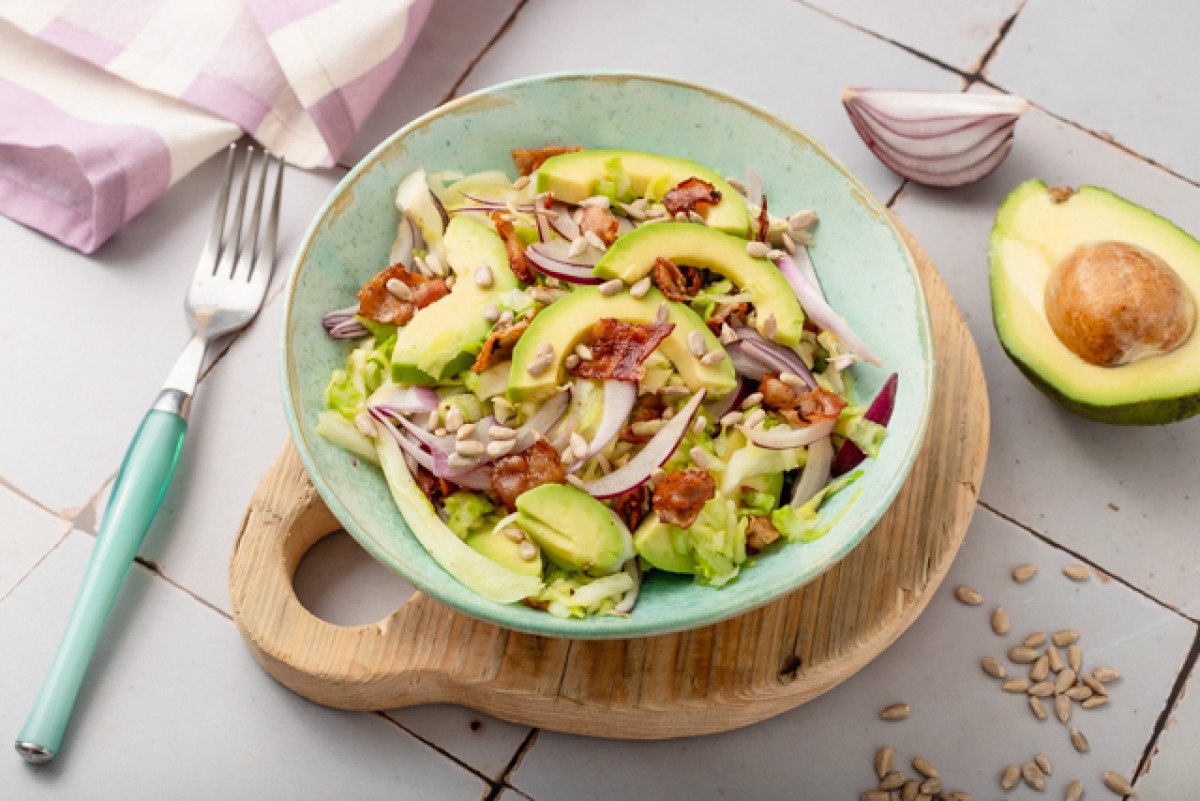 Young cabbage salad with avocado, tomatoes and bacon