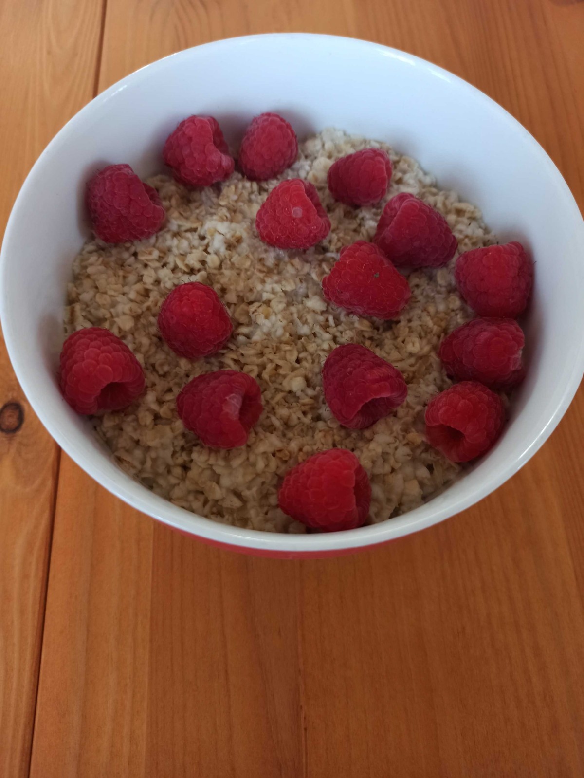Porridge mit heißem Wasser und Himbeeren