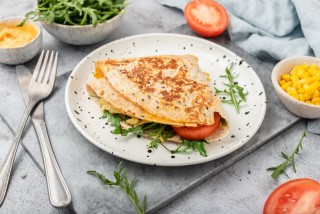 Vegetarian tortilla with hummus, cheddar, rocket and tomato, served warm