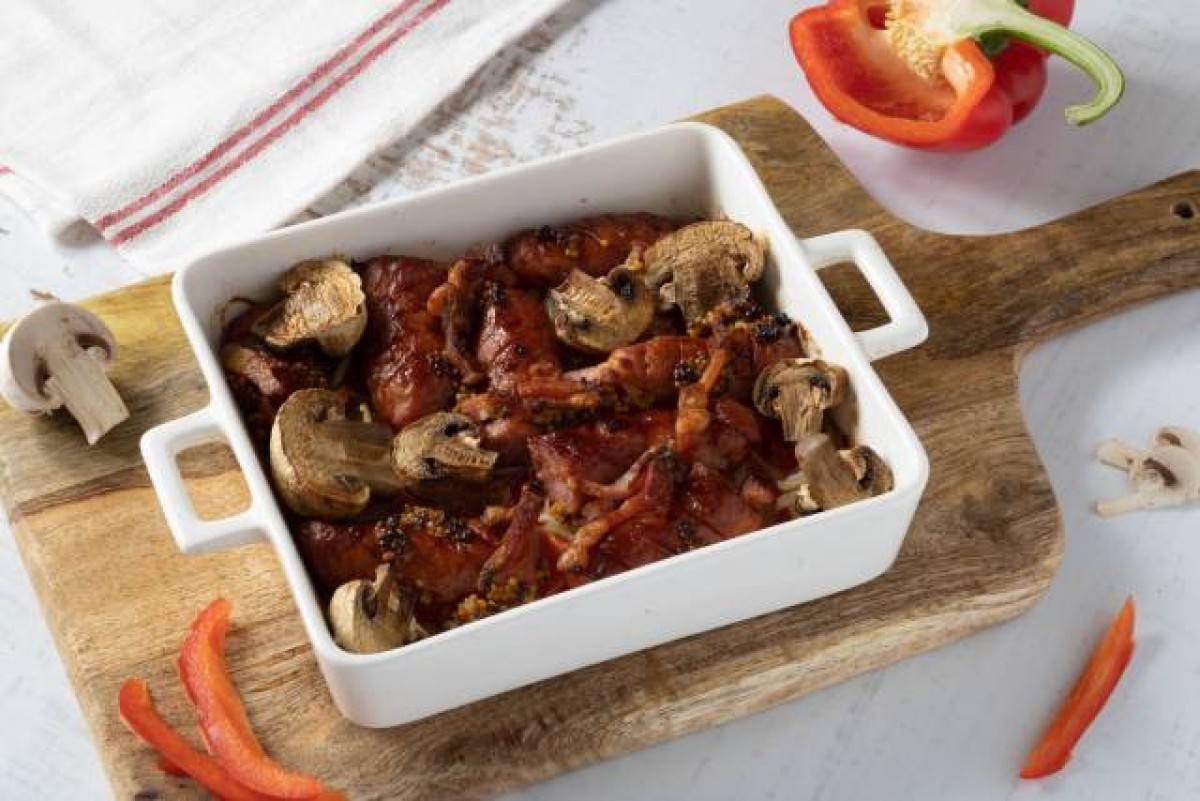 Bratwurst aus dem Ofen mit Zwiebeln, Speck, französischem Senf und Champignons