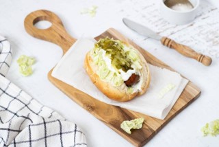 Hot dog with sausage, Chinese cabbage and pickled cucumbers