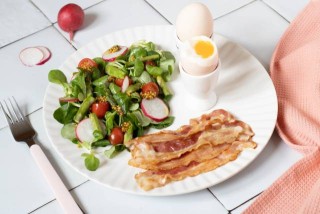 Huevos pasados por agua con ensalada y tocino