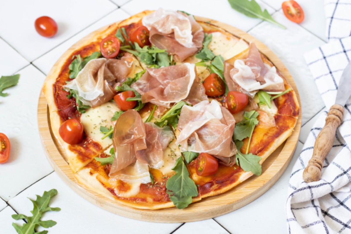 Skyr pizza with rocket, cherry tomatoes, and parma ham