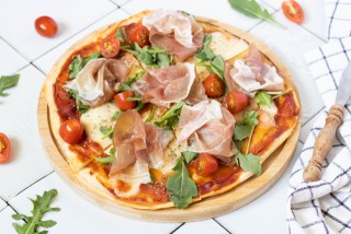Skyr pizza with rocket, cherry tomatoes, and parma ham