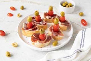 Spanish serrano ham tapas with olives and cherry tomatoes