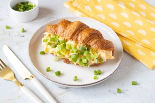Croissant con uova strapazzate, prosciutto ed erba cipollina