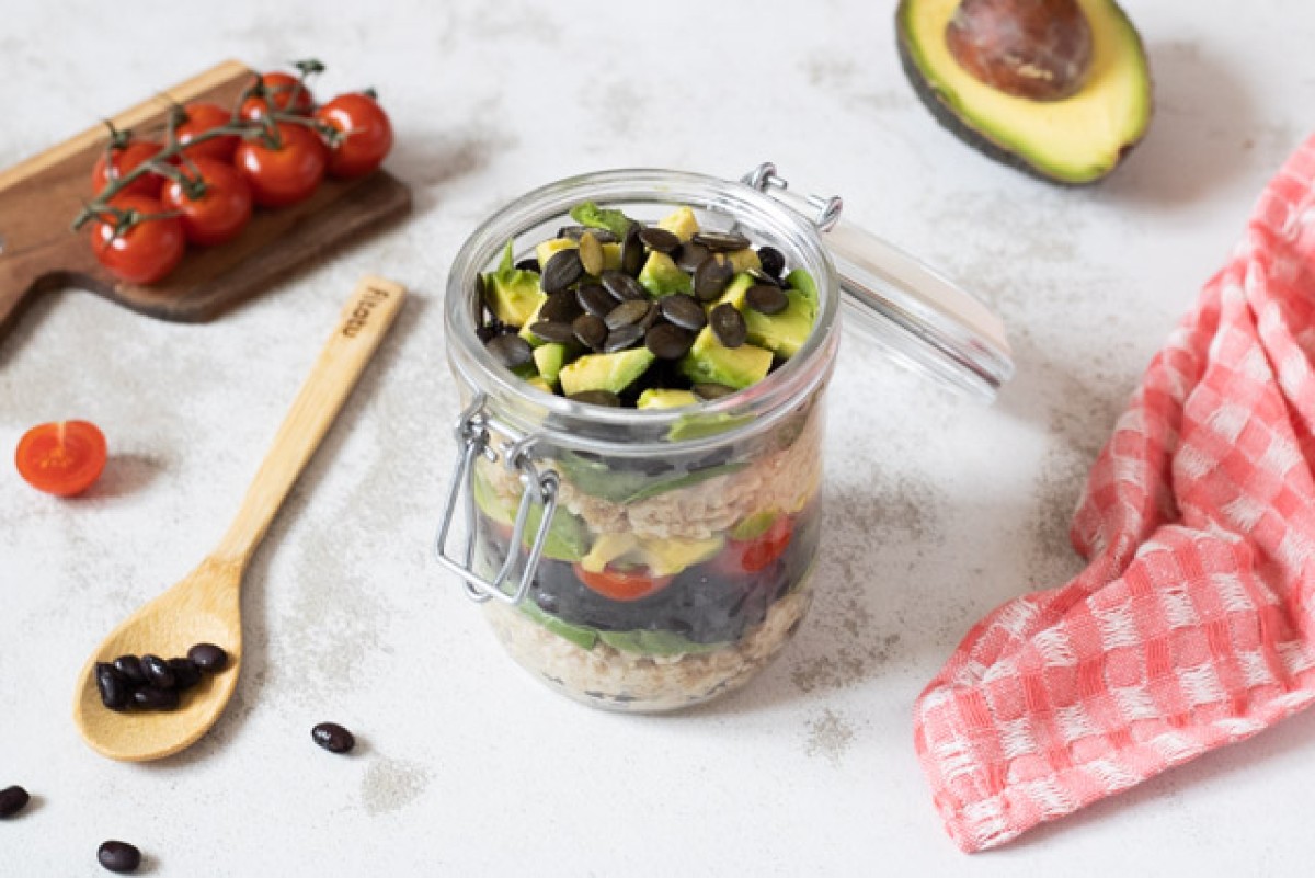 Porridge salato con avocado e fagioli neri in un barattolo