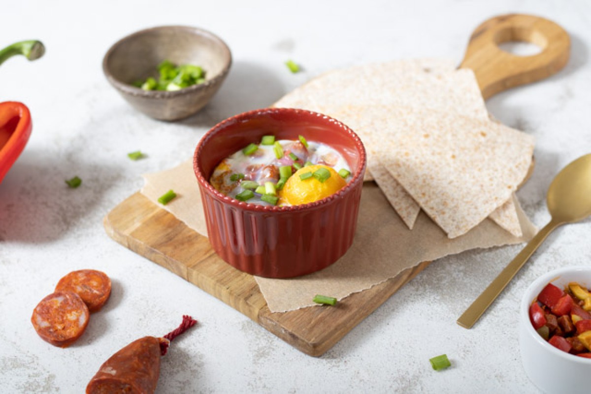 Baked eggs with chorizo and olives with tortilla