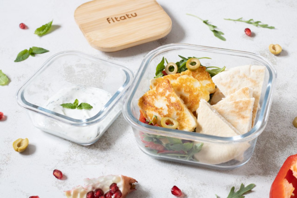 Lunchbox with pita, halloumi, pomegranate salad, and mint sauce