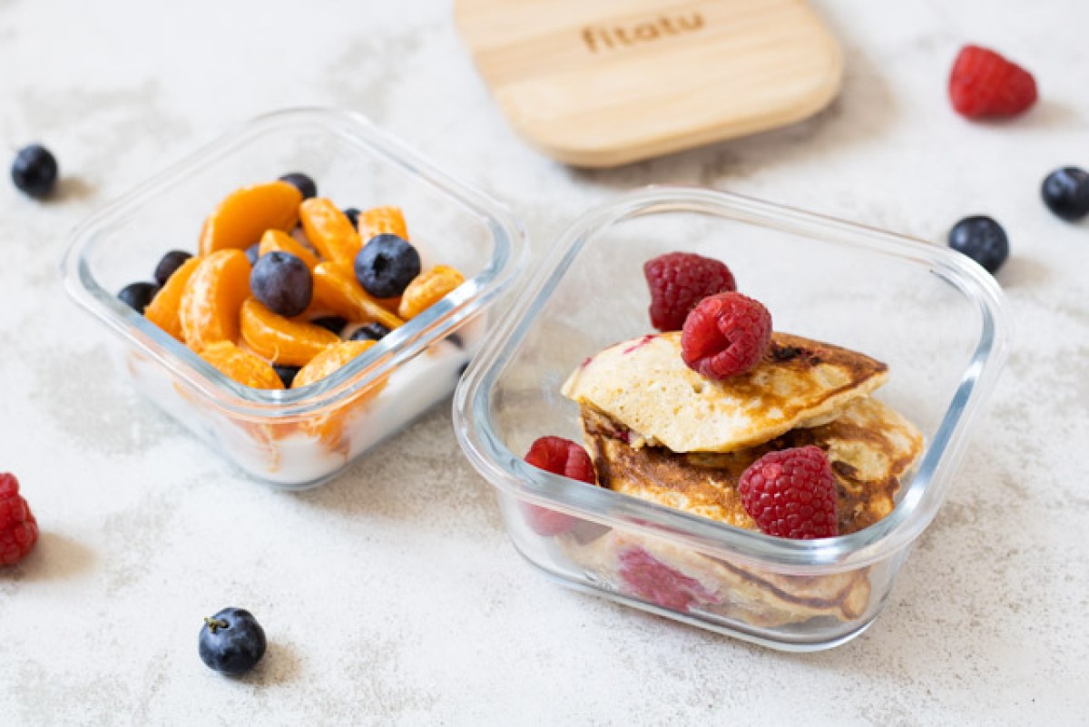 Lunchbox with cheesecake pancakes and fruits