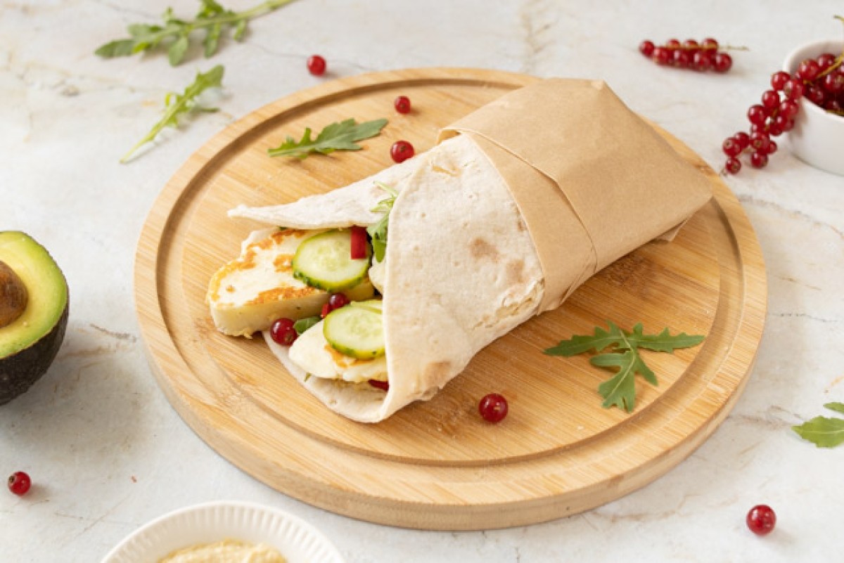 Gluten-free wrap with hummus, avocado, and red currants