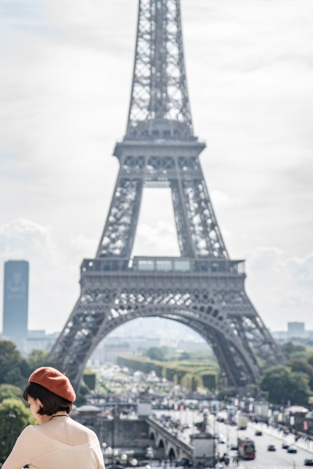 girl with orange beret in front of eiffel tower