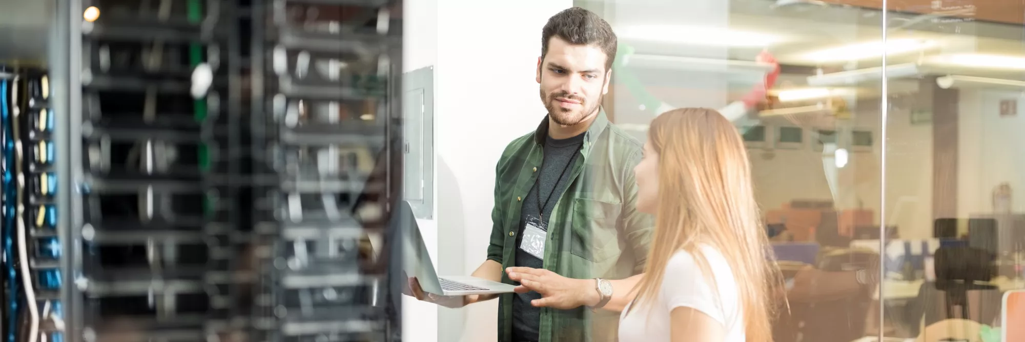 two-business-people-standing-server-room-with-laptop-discussing