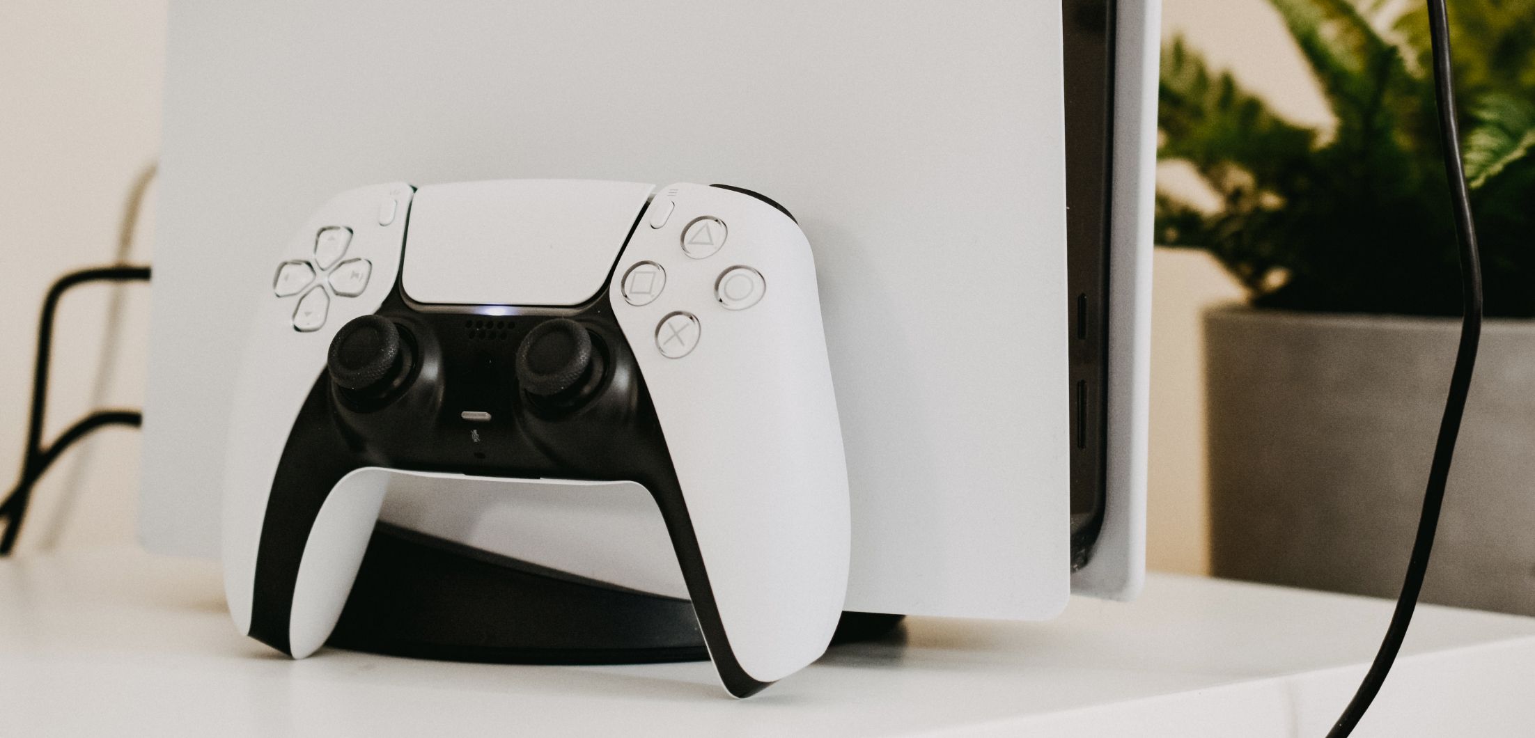 PlayStation-5-Controller lehnt an einer PS5-Konsole.