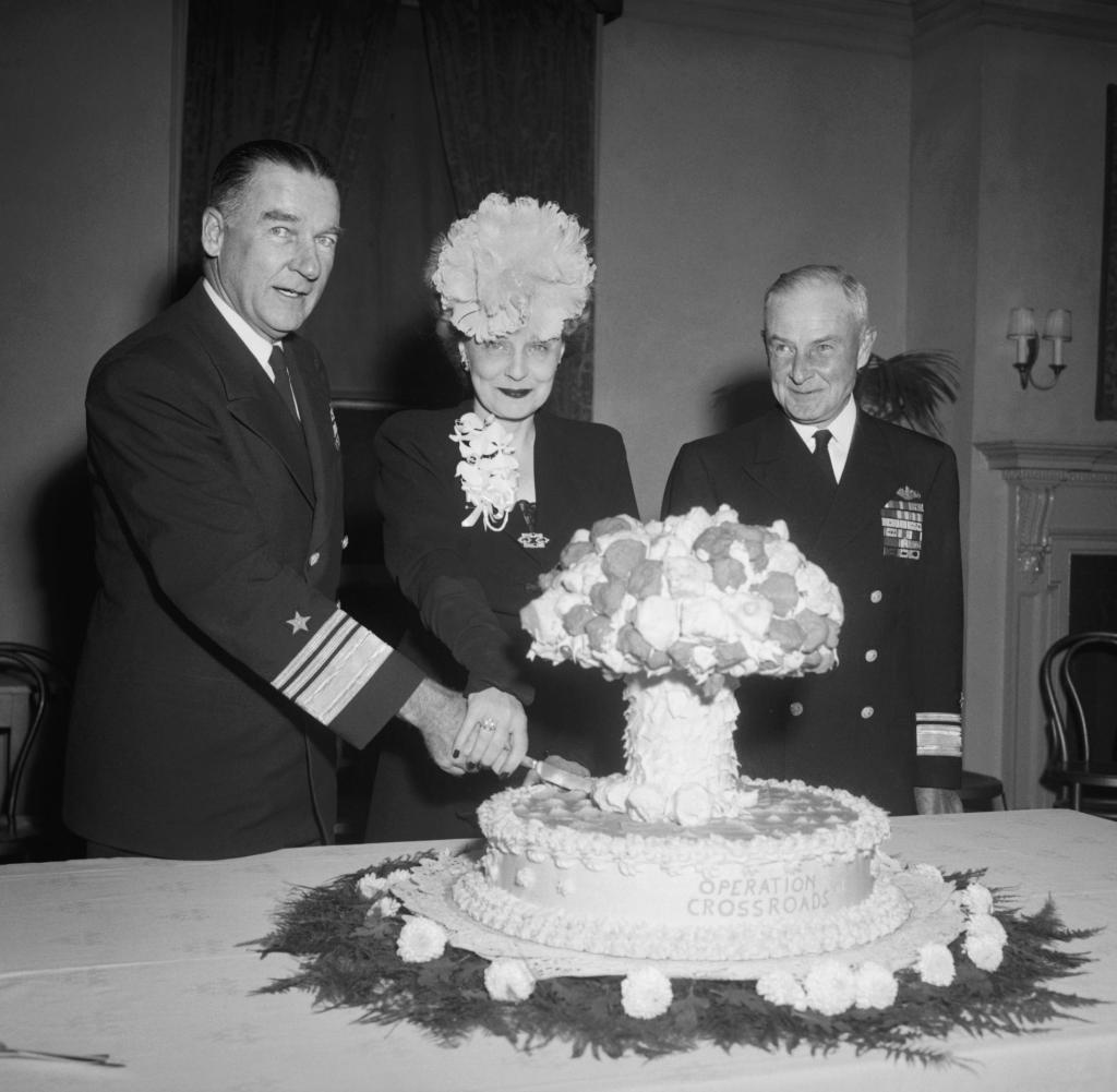 Military-Industrial Complex, Admiral William H.P. Blandy and his wife cut an Operation Crossroads mushroom cloud cake, Washington, D.C., 7 November 1946. Source: Library of Congress, Wikipedia Commons (public domain), StudySmarter.