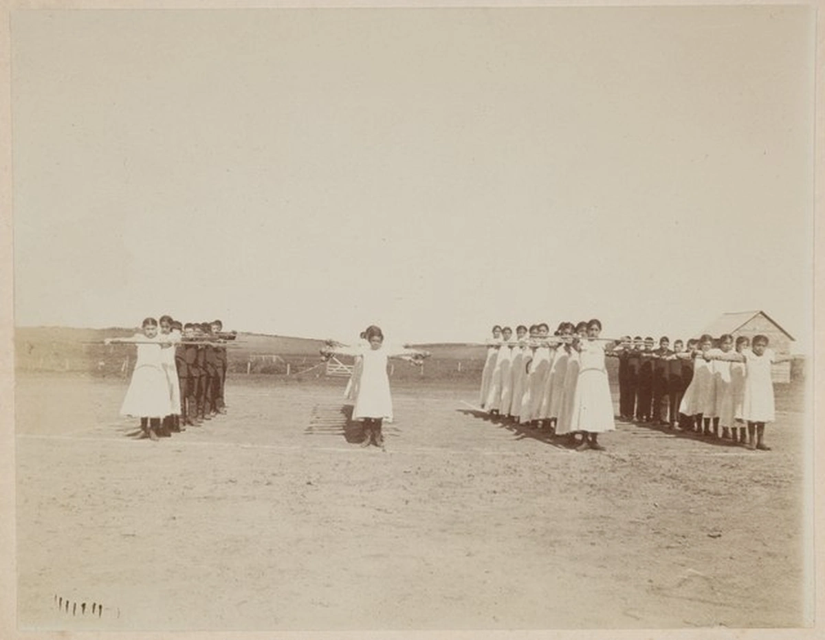 Destruction of Native American Society, Indigenous Native American Children standing outside a boarding School doing their morning excercises, StudySmarter