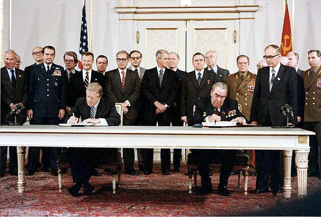Complexe militaro-industriel, Jimmy Carter (États-Unis) et Leonid Brejnev (Union soviétique) signent le traité SALT II, Vienne, Autriche, 18 juin 1979. Source : Wikipedia Commons (domaine public), StudySmarter.