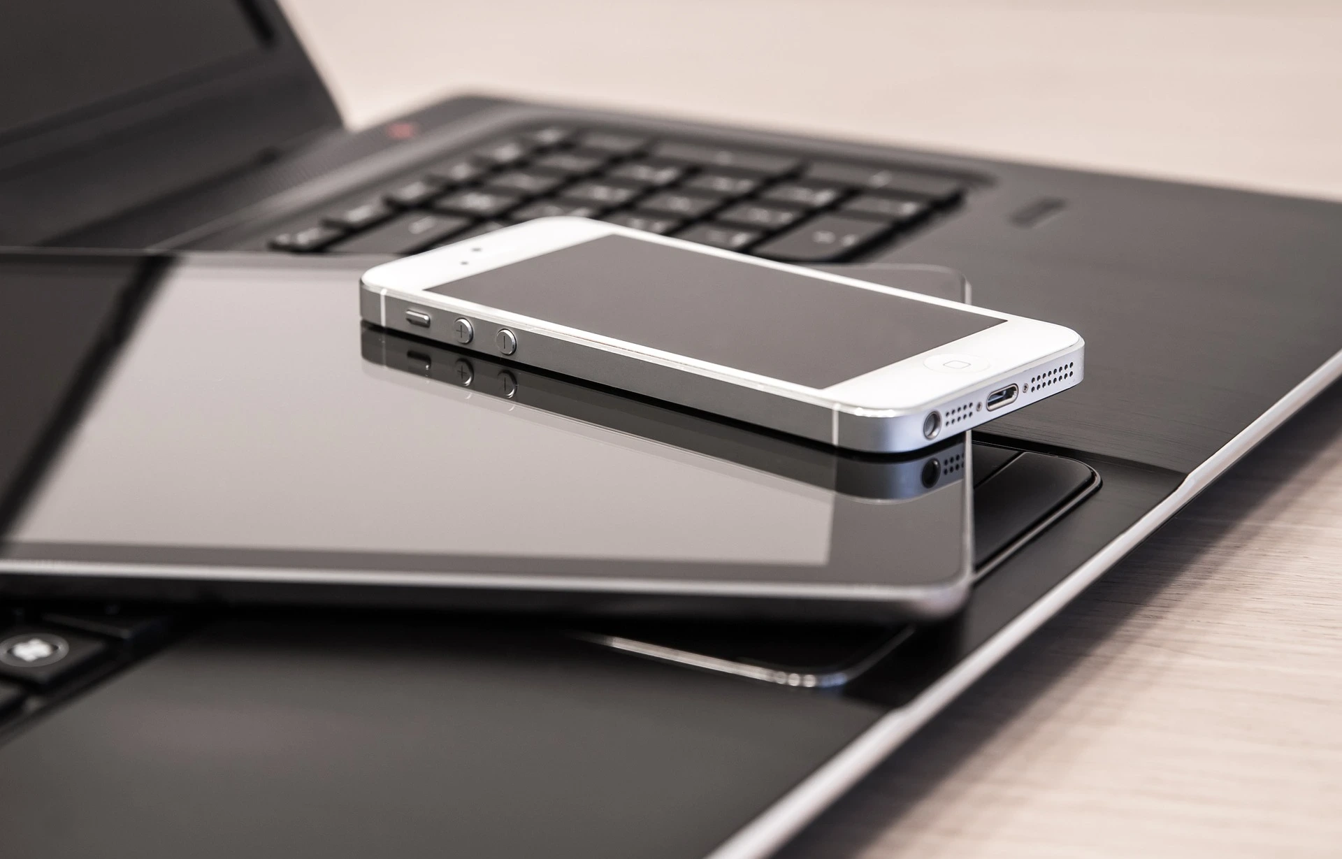 Consumer Spending A smartphone and a tablet laid on a laptop StudySmarter