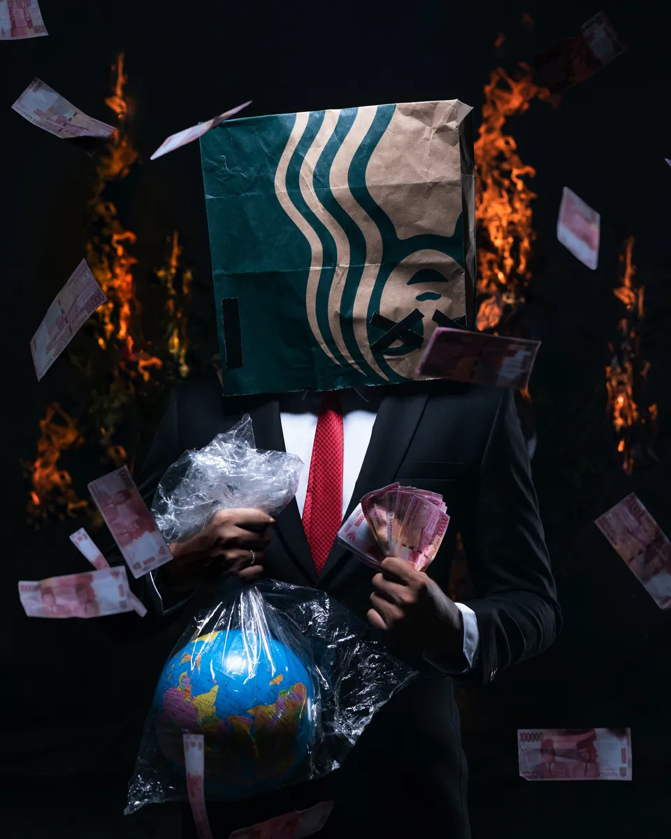 Transnational Corporations, Man with globe in one hand and cash in the other hand and a burning Starbucks bag on his head, StudySmarter (Les sociétés transnationales, un homme avec un globe dans une main et de l'argent dans l'autre et un sac Starbucks en feu sur la tête)