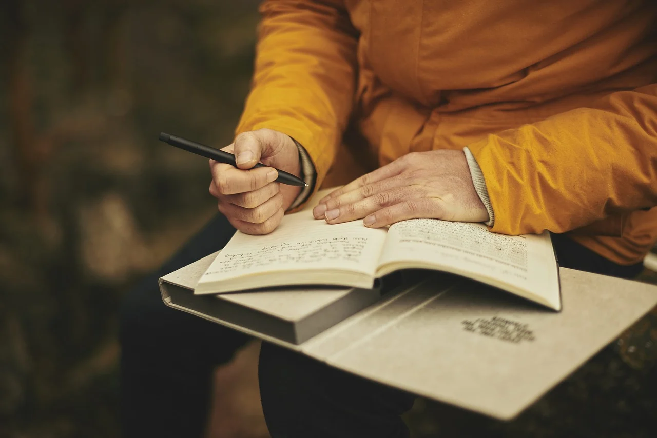 Non-fiction authors, a person writing in a notebook, StudySmarter