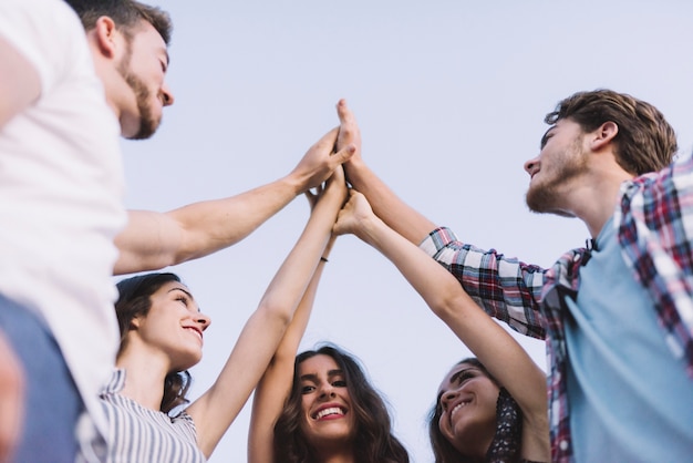 Salud Mental Preventiva, un grupo de jóvenes adultos en círculo chocando los cinco en grupo, StudySmarter