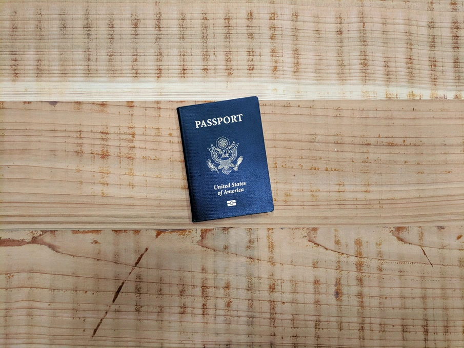 Grupos étnicos en América, Fotografía de un pasaporte estadounidense sobre una superficie de madera, StudySmarter