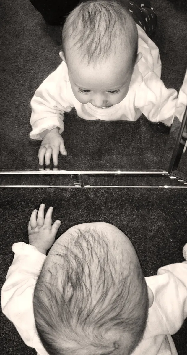 Theories of Socialisation, Baby looking into mirror, StudySmarter