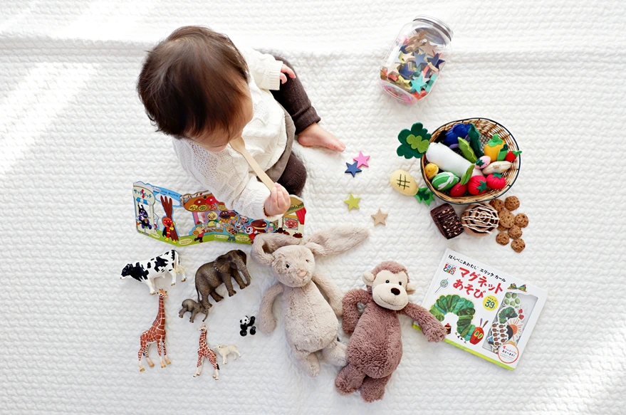 Feminist Perspective on the Family, Birds eye view of infant playing with toys and books, StudySmarter