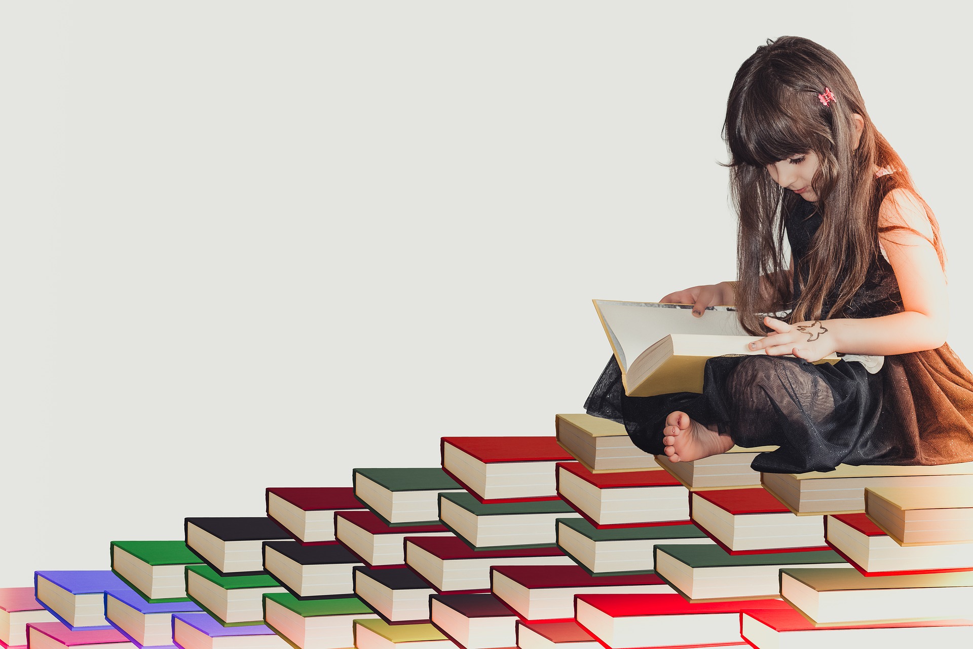 A photo of a young girl reading books, pixabay.com | StudySmarter Original