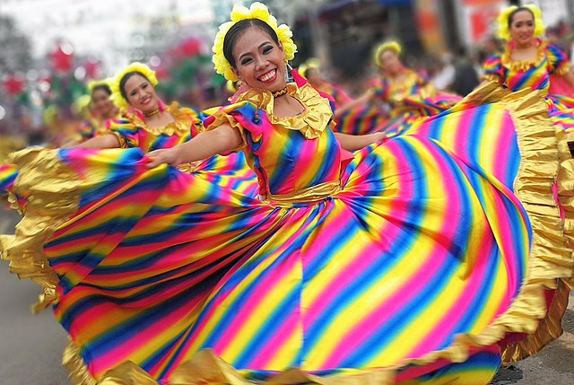 Déplacement angulaire Une personne dansante montrant un mouvement angulaire et un déplacement dans des vêtements colorés au sein d'un groupe de danse StudySmarter