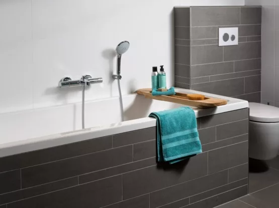 Kleine badkamer met inbouwbad met grijze tegelstroken