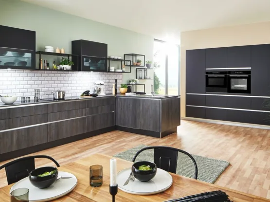 Donkere houten keuken met mat zwarte hoge kastenwand