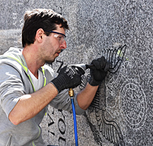 Zhotovení pylonů pro Díky, Ameriko! jde do finále, kamenosochař tesá nápisy