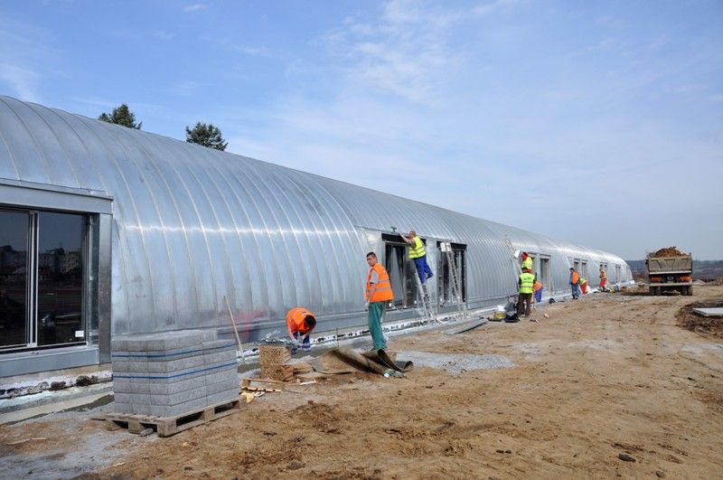 Plzeň se tak bude moci chlubit jedním z nejmodernějších areálů v republice s nejdelším krytým tunelem pro trénování v zimě. Je 123 metrů dlouhý, devět metrů široký, s pěti sto metrů dlouhými drahami a prostorem pro start a cíl.  „Trénovat se tady uvnitř bude moct i skok do dálky,“ dodává Daniel Němeček, autor projektu celého areálu. Vyhřívat jej budou sálavé panely v horní části a stejně jako venkovní plocha bude vybaven tartanem. Tribuna s kapacitou 852 míst je postavena před tunelem. V jejích útrobách vznikají šatny pro klub a školy, velká posilovna, rehabilitace, to všechno včetně zázemí. Vedle stojí rozcvičovna. (foto: 16.4.2013)