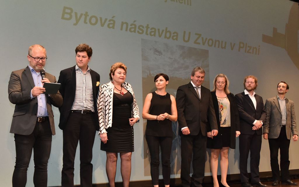 Stavby pro bydleni: Předává Jiří Boudník (architekt a spisovatel) zástupcům projektanta Len+k architekti, s.r.o. (Vladimíra, David a Robert Leníčkovi), zástupcům zhotovitele spol. D-beton s.r.o. (Pavla Altmanová, Jaroslav Vítovec)  a investorovi Gabriele Strakové– Bytová nástavba U Zvonu v Plzni