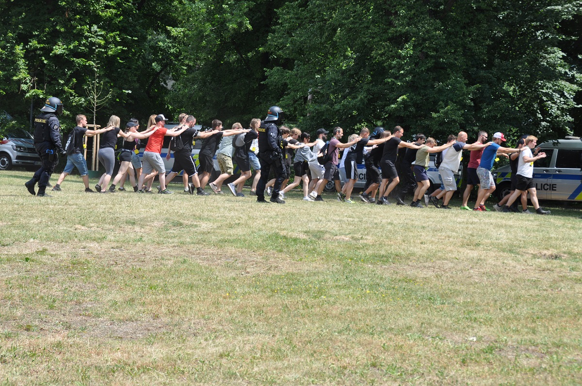 Fotbalový zápas. Vyhrocená atmosféra. Potyčka. Dva fotbaloví chuligáni vytahují střelné zbraně a pálí do lidí… Takový byl námět taktického cvičení AMOK 2022. (foto: H. Josefová, 23.6.2022)