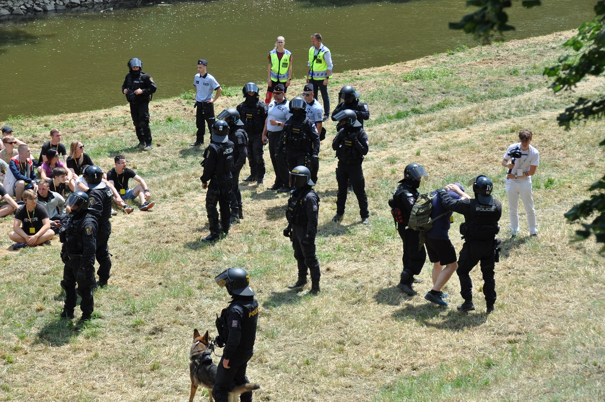 Fotbalový zápas. Vyhrocená atmosféra. Potyčka. Dva fotbaloví chuligáni vytahují střelné zbraně a pálí do lidí… Takový byl námět taktického cvičení AMOK 2022. (foto: H. Josefová, 23.6.2022)