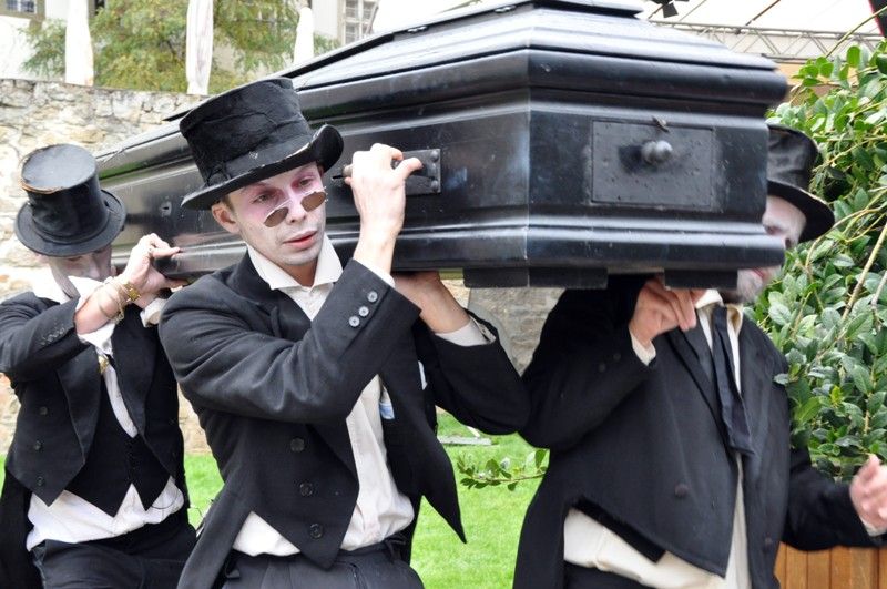 V pátek 13. září 2013 se v Křižíkových sadech objevili čtyři funebráci, kteří s rakví na ramenou a pohřební kapelou v zádech hledali místo, kam pohřbít nebožtíka. Chmurnému průvodu však nebyla dopřána ani chvilka klidu, rakev se změnila v loutkové divadlo nebo kulečníkový stůl, samotní aktéři v kouzelníky a kabaretní umělce. Groteskní eskapádu připravilo pražské uskupení Wariot Ideal v rámci open air programu festivalu Divadlo.