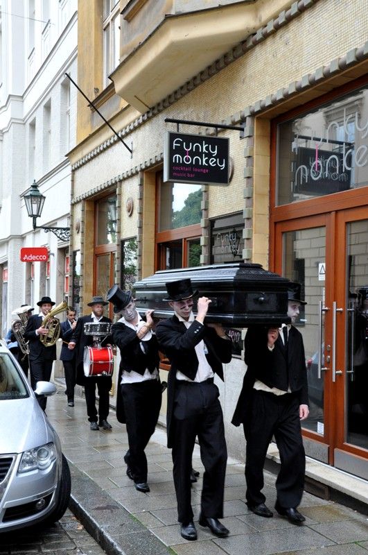 V pátek 13. září 2013 se v Křižíkových sadech objevili čtyři funebráci, kteří s rakví na ramenou a pohřební kapelou v zádech hledali místo, kam pohřbít nebožtíka. Chmurnému průvodu však nebyla dopřána ani chvilka klidu, rakev se změnila v loutkové divadlo nebo kulečníkový stůl, samotní aktéři v kouzelníky a kabaretní umělce. Groteskní eskapádu připravilo pražské uskupení Wariot Ideal v rámci open air programu festivalu Divadlo.