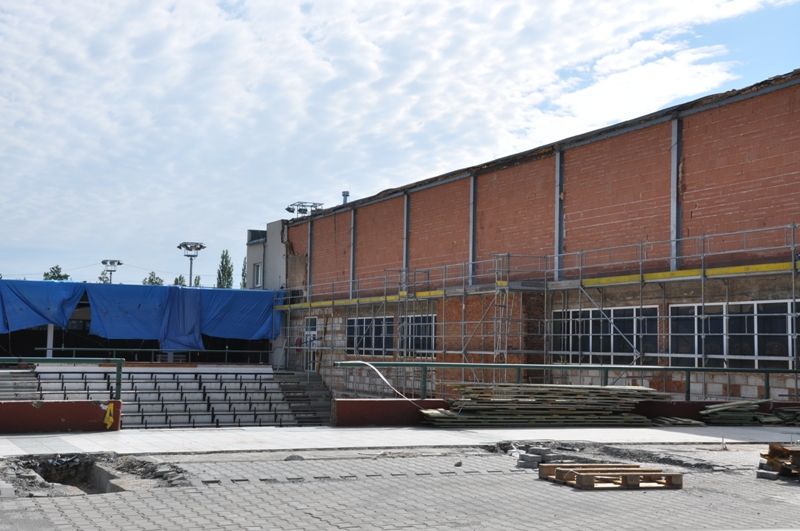 O dva měsíce se prodloužila oprava městské sportovní haly na Slovanech. Důvodem zdržení rekonstrukčních prací je zjištění nevyhovující pevnosti betonů stávajících základových konstrukcí. „Pevnost betonů bylo možné ověřit až po demolici původní konstrukce. Museli jsme nechat vypracovat nové technické řešení úpravy, na jehož základě byl u dvou patek navržen nový princip založení. Proto bylo nezbytně nutné prodloužit termín dokončení stavby včetně vydání kolaudačního souhlasu, a to do 15. prosince,“ uvádí Veronika Krupičková z odboru správy infrastruktury. V současné době se buduje střešní plášť, vyzdívky obvodových stěn a dokončují se práce na ocelové konstrukci, montážních lávkách nebo na přepojování trafostanice. Následovat bude dokončení střešního pláště a příprava na osazování výplní obvodových stěn. (foto: 17.6.-19.9.2013)