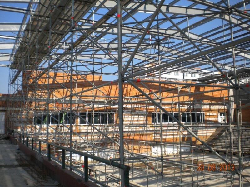 O dva měsíce se prodloužila oprava městské sportovní haly na Slovanech. Důvodem zdržení rekonstrukčních prací je zjištění nevyhovující pevnosti betonů stávajících základových konstrukcí. „Pevnost betonů bylo možné ověřit až po demolici původní konstrukce. Museli jsme nechat vypracovat nové technické řešení úpravy, na jehož základě byl u dvou patek navržen nový princip založení. Proto bylo nezbytně nutné prodloužit termín dokončení stavby včetně vydání kolaudačního souhlasu, a to do 15. prosince,“ uvádí Veronika Krupičková z odboru správy infrastruktury. V současné době se buduje střešní plášť, vyzdívky obvodových stěn a dokončují se práce na ocelové konstrukci, montážních lávkách nebo na přepojování trafostanice. Následovat bude dokončení střešního pláště a příprava na osazování výplní obvodových stěn. (foto: 17.6.-19.9.2013)