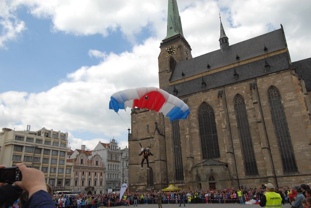 Devět bravurních seskoků předvedli parašutisté z Aeroklubu Plzeň Bory návštěvníkům odpoledního programu Slavností svobody. Zcela zaplněné náměstí lidmi vyjma prostoru pro seskok o rozměru 30 krát 30 metrů bylo svědkem ve třech vlnách po sobě jdoucích skoků z letounu AN 2, který při výsadku ve výšce jeden tisíc metrů letěl rychlostí zhruba 80 – 120 kilometrů za hodinu. Výsadkáři se pak nad náměstím Republiky snášeli rychlostí pět metrů za sekundu. Do cíle pánové Michal Brožek, Jan Bečka, Gerald Vágner, Viktor Kubáň, Michal Cihlář, Miroslav Musil, Pavel Blahout, Tomáš Tázler a Josef Muhr doskočili po třech až pěti minutách. Letoun pilotovala Ivana Bečková, palubním technikem byl Hynek Kropáč. (foto: 4.5.2014)