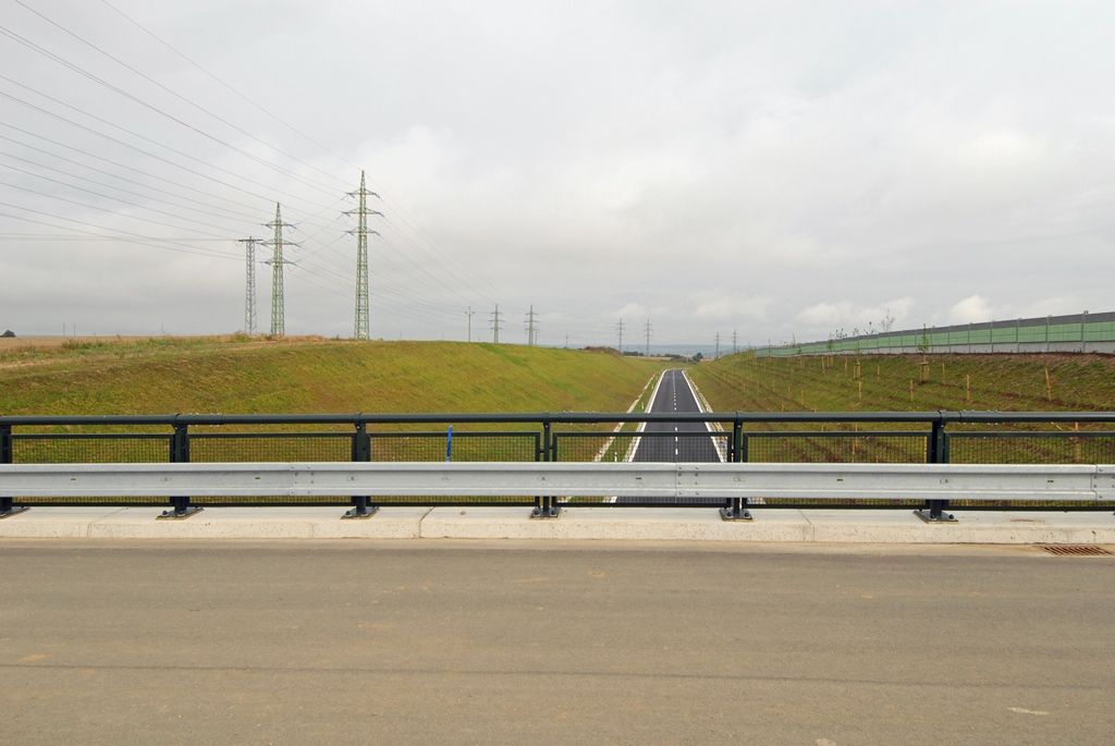 Celá 2,1 kilometru dlouhá první etapa obchvatu, jejíž výstavba začala v září roku 2012 a spojí průmyslovou, obchodní a vysokoškolskou zónu Borská pole se silnicí směrem na Cheb v Křimicích, bude otevřena 9. září. V budoucnu na ni naváže druhá část o délce 3,3 kilometru. Propojit má Chebskou ulici se Severním předměstím. (foto: 5.8.2014)