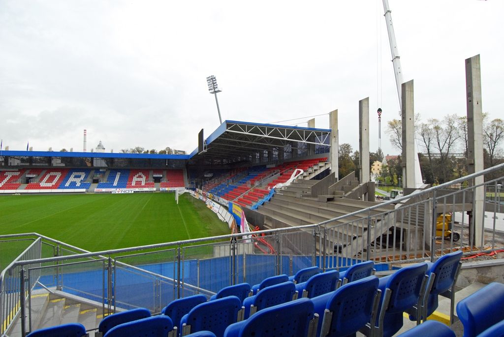Jasné obrysy v těchto dnech získává chybějící modul jižní strany tribuny fotbalového stadionu ve Štruncových sadech. Jedná se o nosnou betonovou prefabrikovanou konstrukci založenou na pilotech. Z vnější strany má být opatřena ocelovou lamelovou fasádou, stejně jako ostatní části tribuny. V modulu je rovněž navrženo rozšíření stávajícího stánku na občerstvení nebo vybudování skladového prostoru. Navíc tady vzniknou dvě nová televizní studia. Divácká kapacita se díky dostavbě tribuny zvýší o 300 míst. Hotovo má být do konce tohoto roku. (foto: 13./17.10.2014)