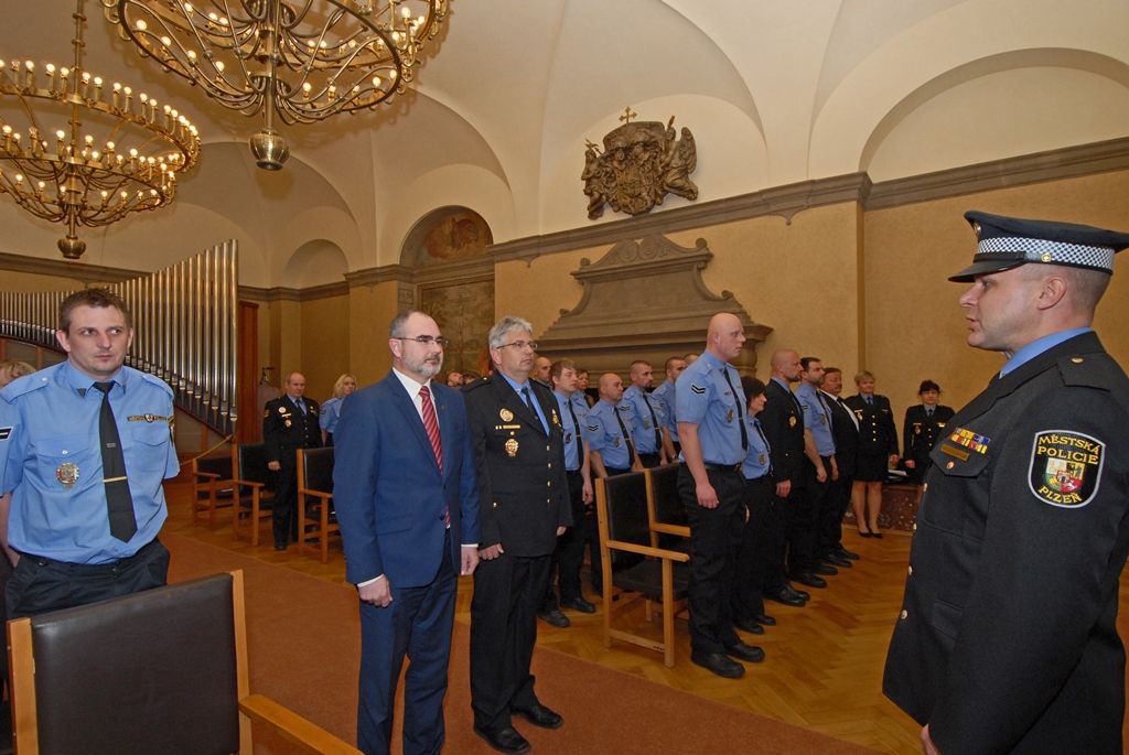 Ocenění za věrnost, dále také za statečnost, mimořádné činy a záchrany životů si dnes (22.4.2015) v obřadní síni plzeňské radnice převzalo přes 70 strážníků a zaměstnanců Městské policie Plzeň. Mezi těmi, kteří obdrželi čestné stužky a řády, jsou příslušníci vykonávající svoji práci 5, 10, 15 i 20 let, ale také ti, kteří pomohli zachránit život sebevrahům, poskytli první pomoc lidem v bezvědomí, zakročili proti pachatelům vloupání, a to ať již ve službě nebo v době osobního volna, zasáhli proti skupině agresivních osob a podobně. Medaili cti z rukou primátora převzala lékařka Světlana Čuntalová, která loni 13. září pomohla spolu se strážníky chodkyni, již srazilo vozidlo v sadech Pětatřicátníků v Plzni, před příjezdem záchranářů jí poskytla první pomoc. Druhou Medaili cti obdržel Pavel Krákora, ředitel Městského ředitelství policie Plzeň, a to za spolupráci s městskou policií při řešení bezpečnosti a veřejného pořádku.