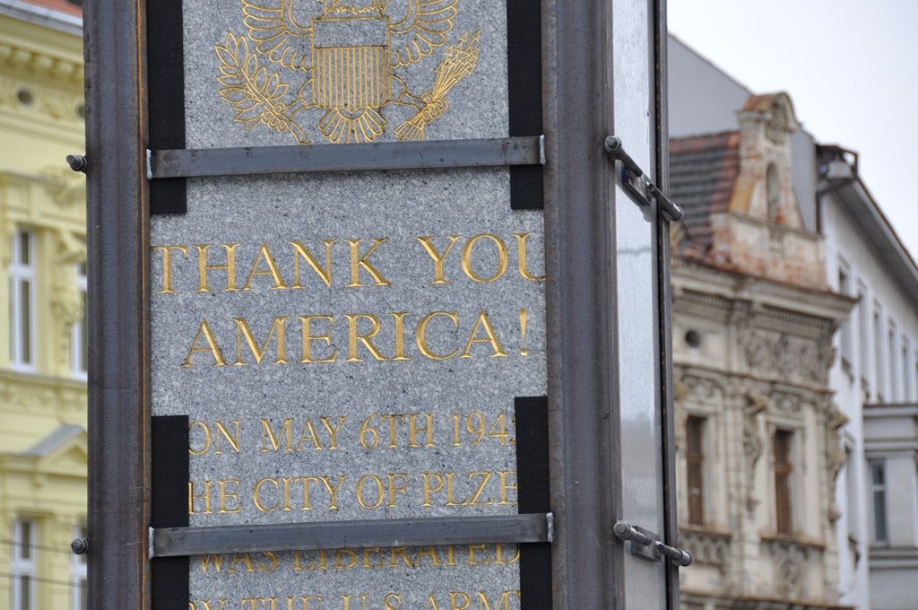 Zhruba deset hodin trvaly sobotní práce na odstranění dvou poškozených žulových pylonů pomníku Díky, Ameriko! v Plzni. Na technicky náročný zákrok se přišlo postupně podívat během dne několik stovek lidí. Specializovaná firma už v pátek zpevnila mnohatunové kvádry bandáží, aby je stáhla, dnes pak pomocí lanové pily oba dva odřízla ve výšce 38 centimetrů nad zemí. Na torzo obou pylonů byl kolem 19:00 nasazen tubus z nerezového plechu, který místo důstojně zakrývá a zůstane do doby, než budou zhotoveny pylony nové. (foto: 23.4.2016, E. Barborková)