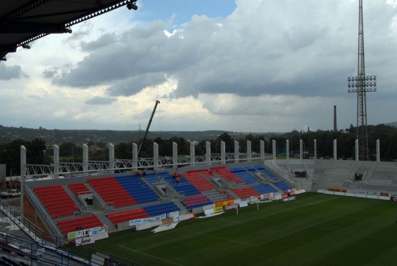 Přestavba stadionu ve Štruncových sadech je o krok dál – sedačkami jsou již osazeny obě tribuny za brankami. Stavebníci také montují střešní nosníky u obou tribun.