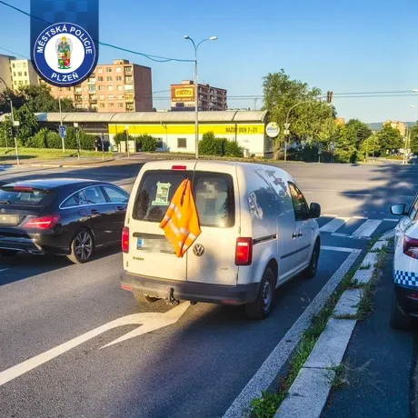 Odstavené vozidlo a řidič sedící v pivnici