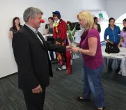 Starosta MO 3 Jiří Strobach předává květinu pí. vychovatelce Petrovičové, vedoucí pěvěcekého sboru DD Domino.